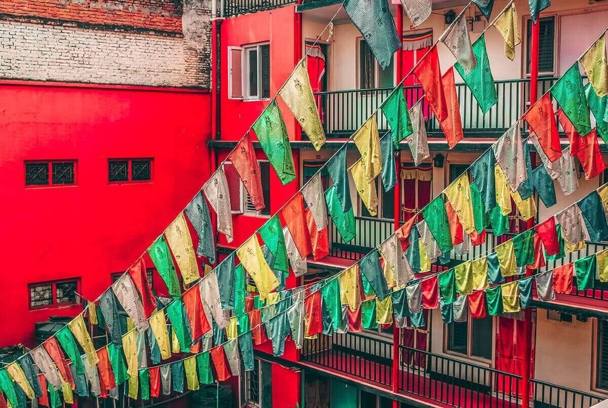 Backpacking Kathmandu: Everything Travelers Need To Know 2 red buildings with pray flags hanging off the balcony in kathmandu