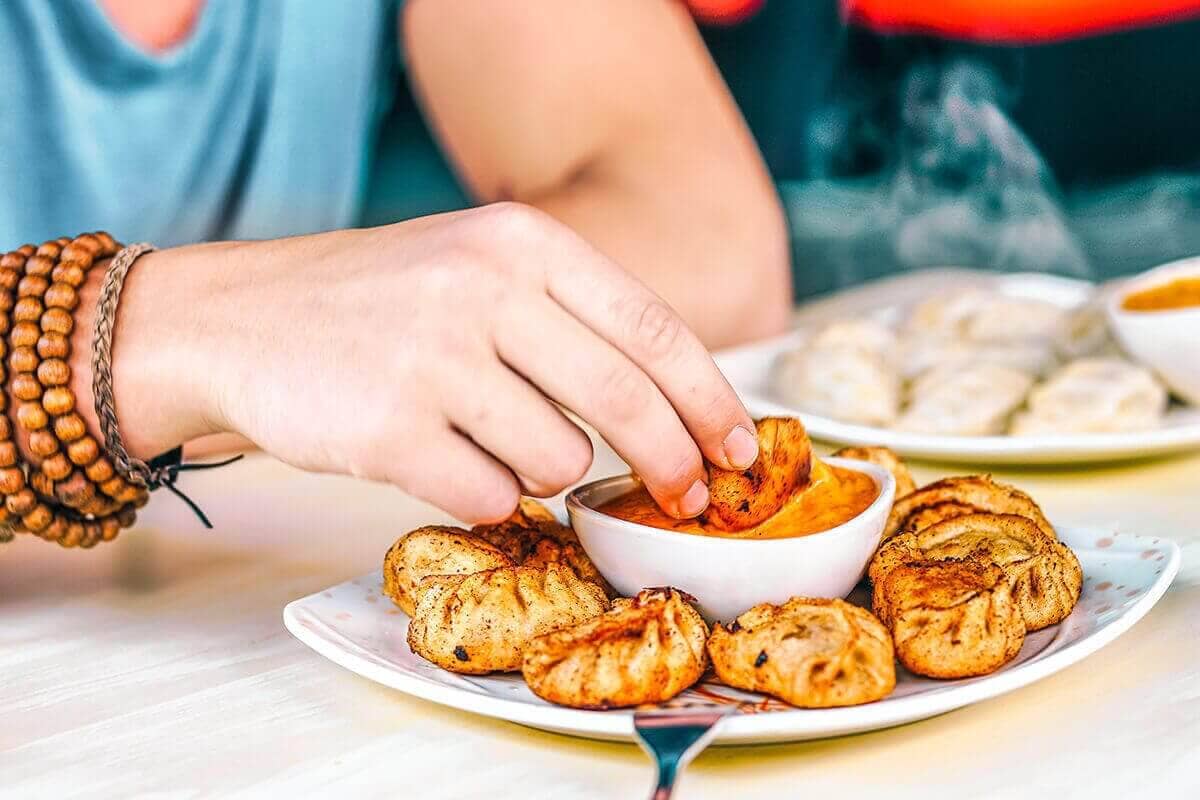 Backpacking Kathmandu: Everything Travelers Need To Know 10 eating fried momos while backpacking kathmandu