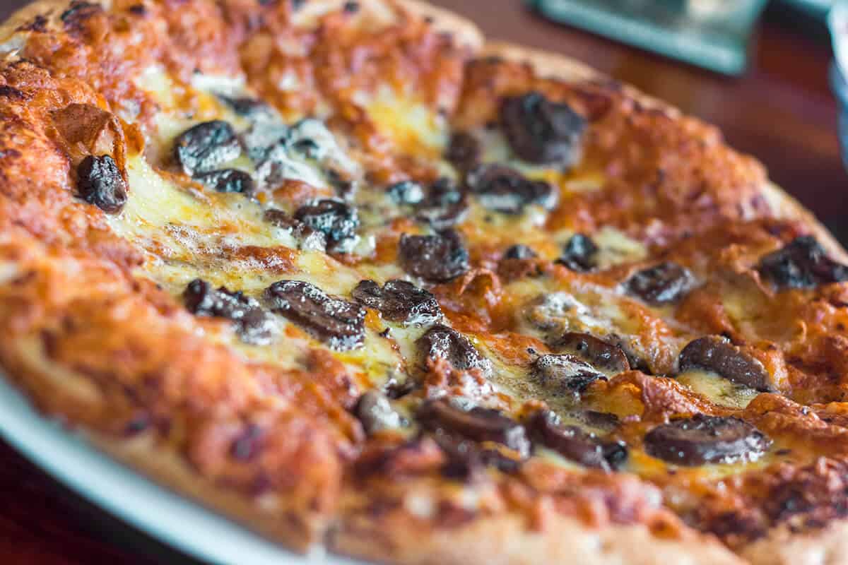 Backpacking Rarotonga On A Budget: Top Travel Tips 16 a mushroom pizza from trader jacks in rarotonga