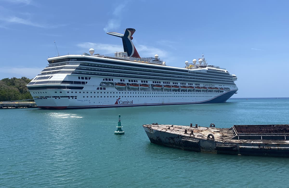 Backpacking Roatan & BEST Hostels In Roatan (2025) 18 a large carnival cruise ship in port at roatan