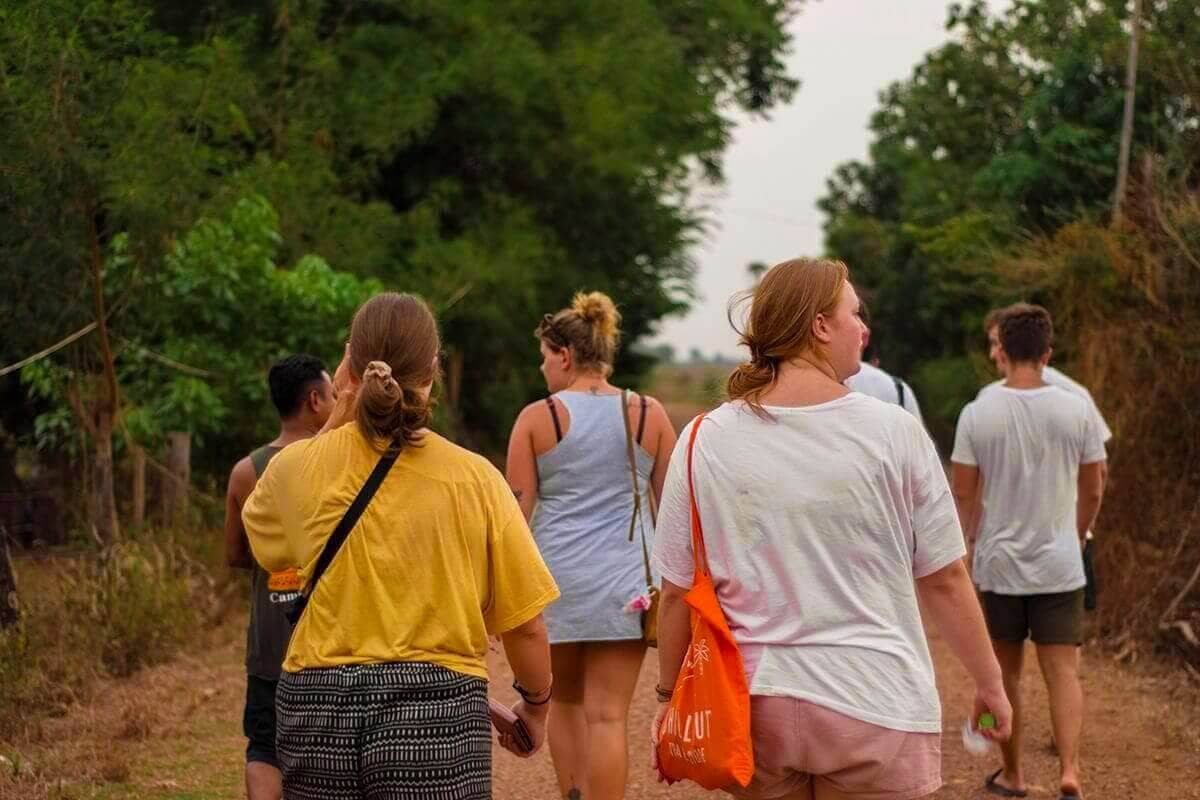First Time In Southeast Asia? Group Tour VS Solo Travel 2 walking through the countryside of battambang cambodia with stray asia