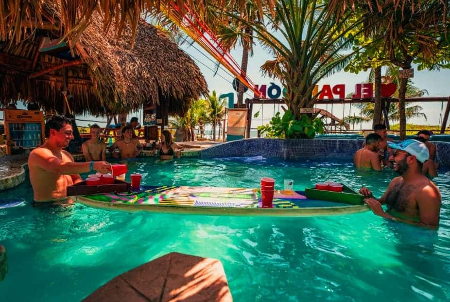 Best Hostels In El Paredon: 8 Hostels For The Perfect Stay 2025 15 having a game of beer bong on a surfboard at the driftwood surfer hostel