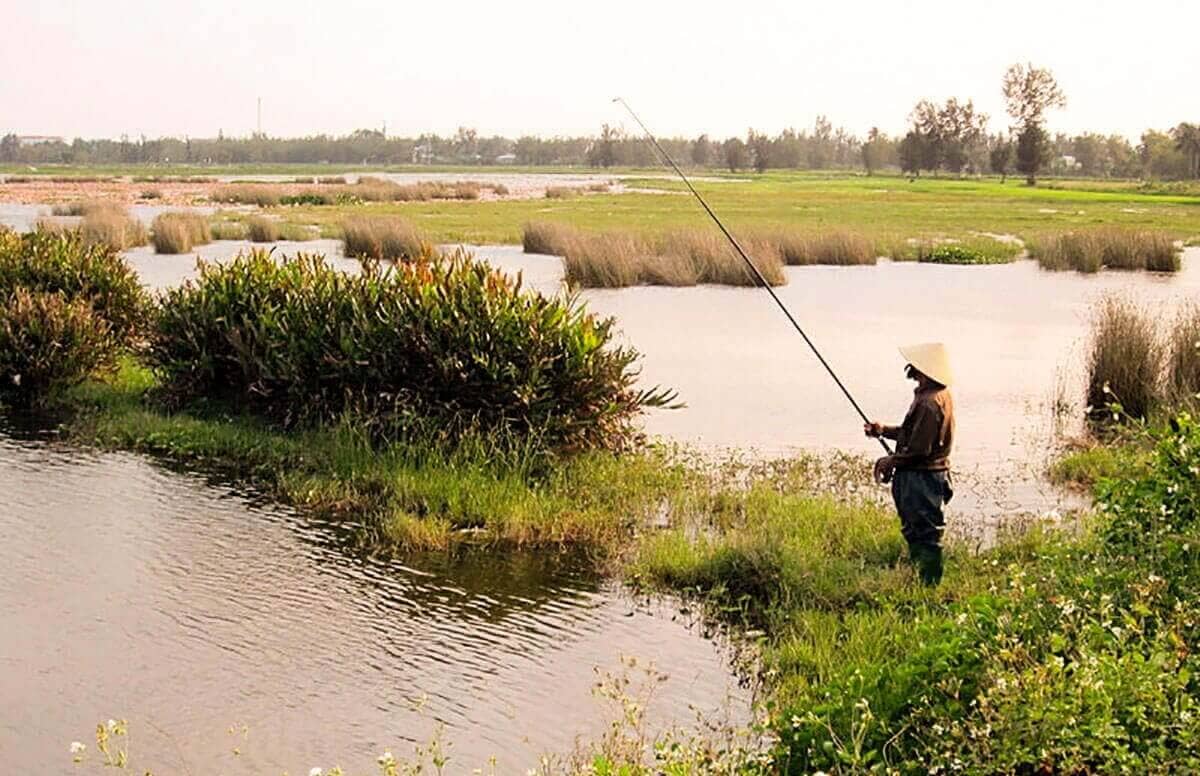 The Best Things To Do In Vietnam Recommended By REAL Travelers 21 fisherman standing in waterway at cam kim vietnam