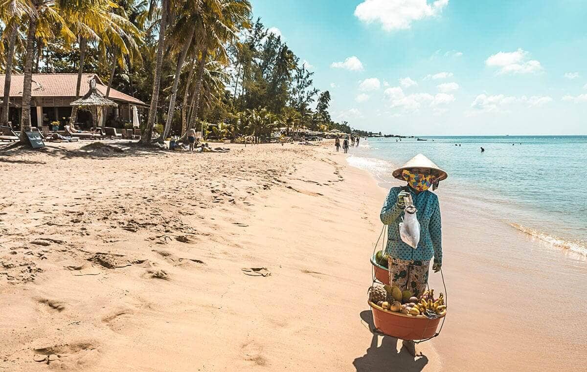 The Best Things To Do In Vietnam Recommended By REAL Travelers 30 vietnamese lady holding basket of fruit at beach in phu quoc