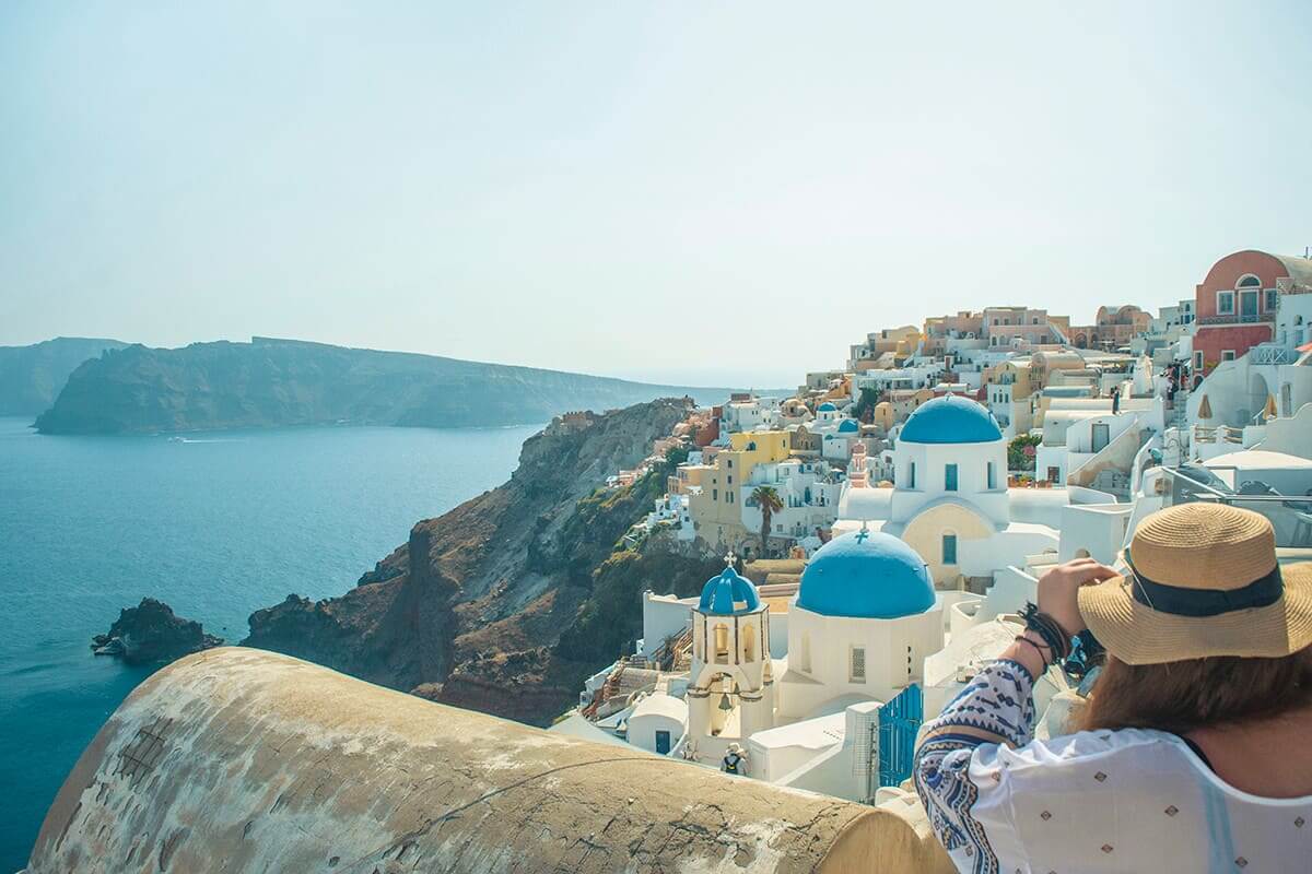 The Cost To Travel Greece And How Expensive Is It? 4 watching the clifftop views in santorini cost to travel greece