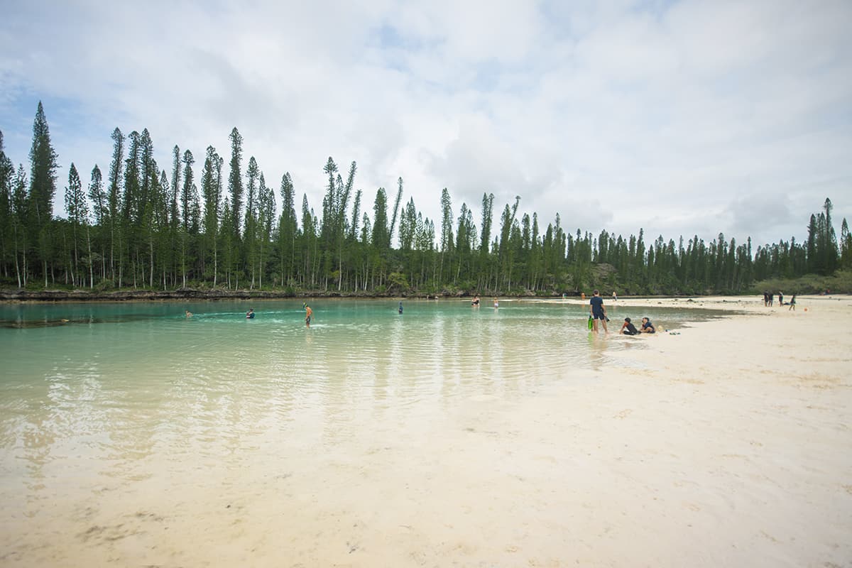 Isle Of Pines Natural Pool: Why You NEED To Visit 2025 5 holiday makes and a few cruise goers checking out the natural pool in isle of pines during a low tide and slightly overcast day