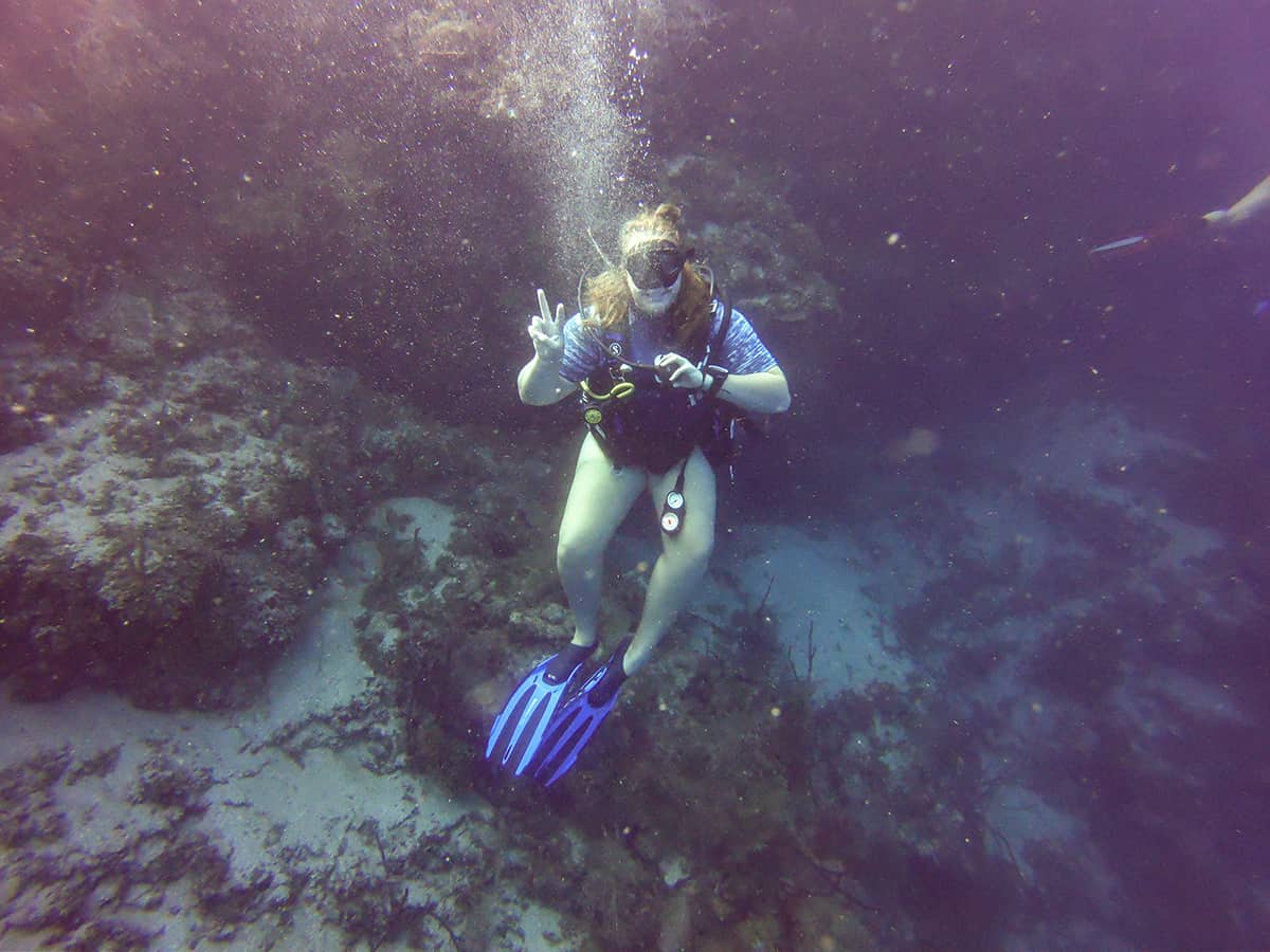 Learn To Dive In Roatan: Scuba Diving Roatan Companies, Prices & What To Expect 24 yes another peace sign but this time i removed my regulator for an unobstructed smile