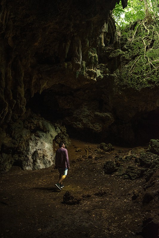 A man standing in front of Queen Hortense's Cave on the Isle Of Pines.
	