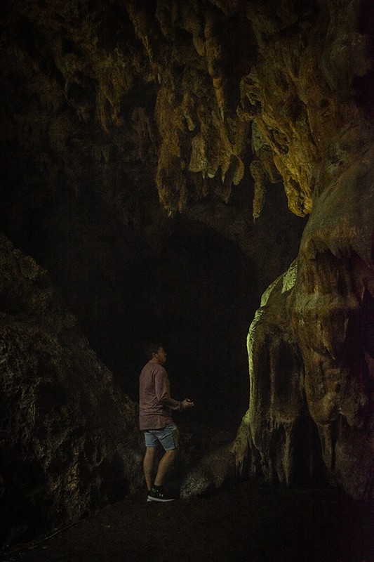 A man standing in front of Queen Hortense’s Cave on the Isle Of Pines.
	