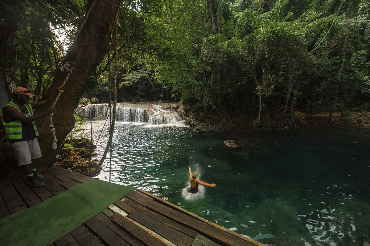 Rarru Cascades In Port Vila: BEST Tips For Visiting 2025 12 a women splashing into the water at rarru cascades after jumping off one of the platforms