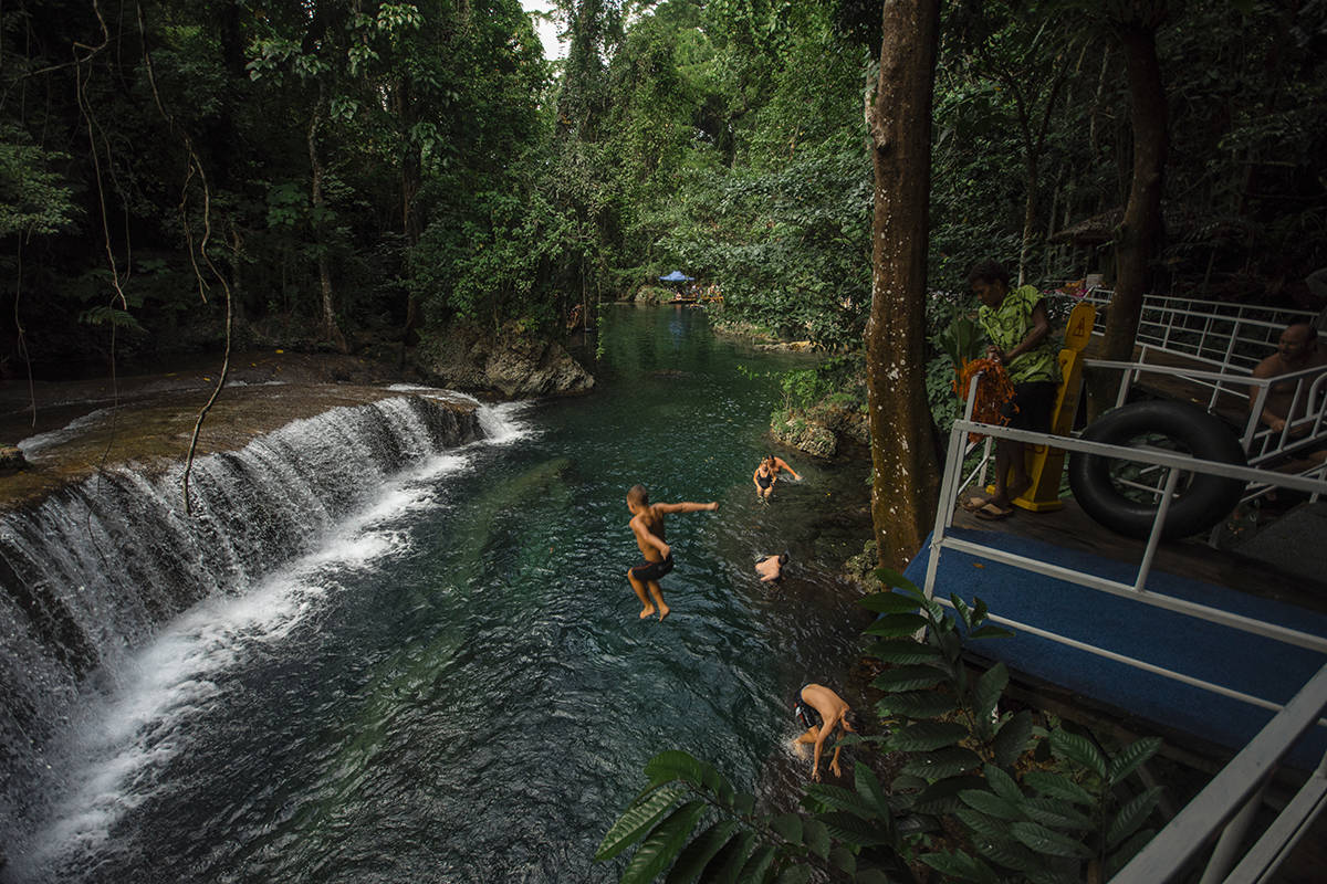 Rarru Cascades In Port Vila: BEST Tips For Visiting 2025 4 people jumping off the platform into the water at rarru cascades in port vila