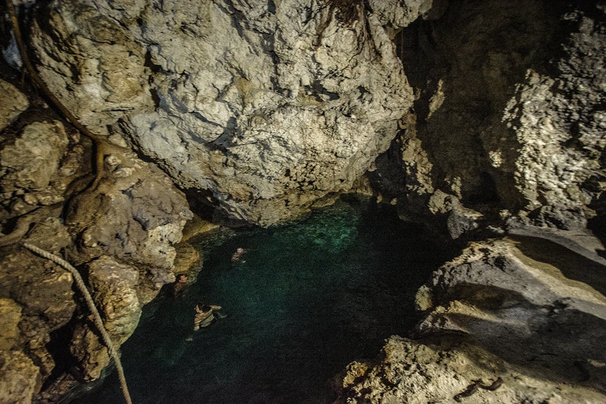 The Secret Grotto In Lifou: All You NEED To Know 2025 13 swimming in the bright blue waters lit up by torches in lifou