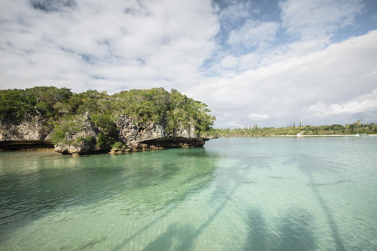 Things To Do In Isle Of Pines: For Cruise Passengers & More 13 palm tree shadows in the ocean looking out to the sacred rock