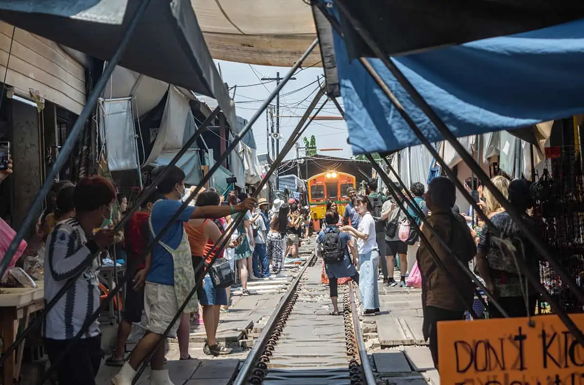 2 Days In Bangkok Itinerary: The ULTIMATE Guide 2025 17 watching the train come through the maeklong railway market with sellers about to pull back the awnings