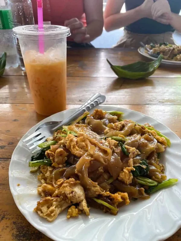 2 Days In Bangkok Itinerary: The ULTIMATE Guide 2025 7 lunch consisting of pad see ew and a thai iced tea in bangkok