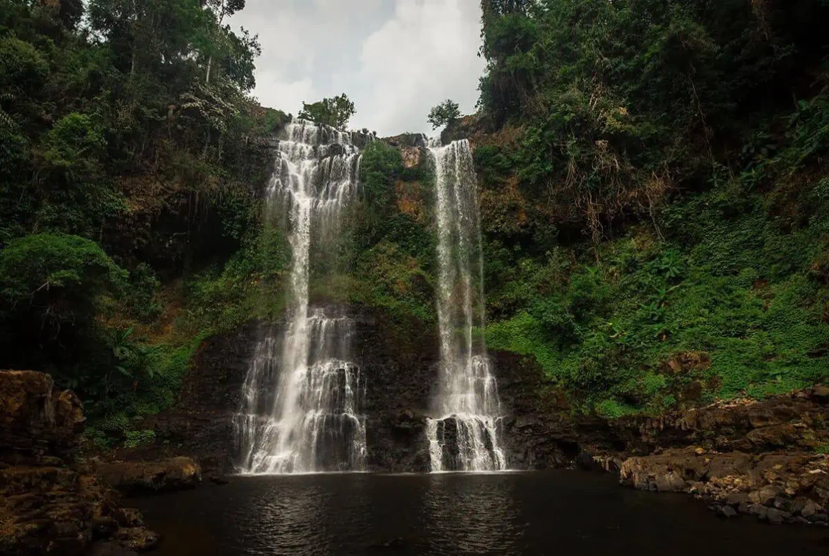 2 Weeks In Laos Itinerary: BEST Route North To South 43 double falls flowing into a pool at tad yuang waterfall in pakse, a must visit on the 2 week in laos itinerary
