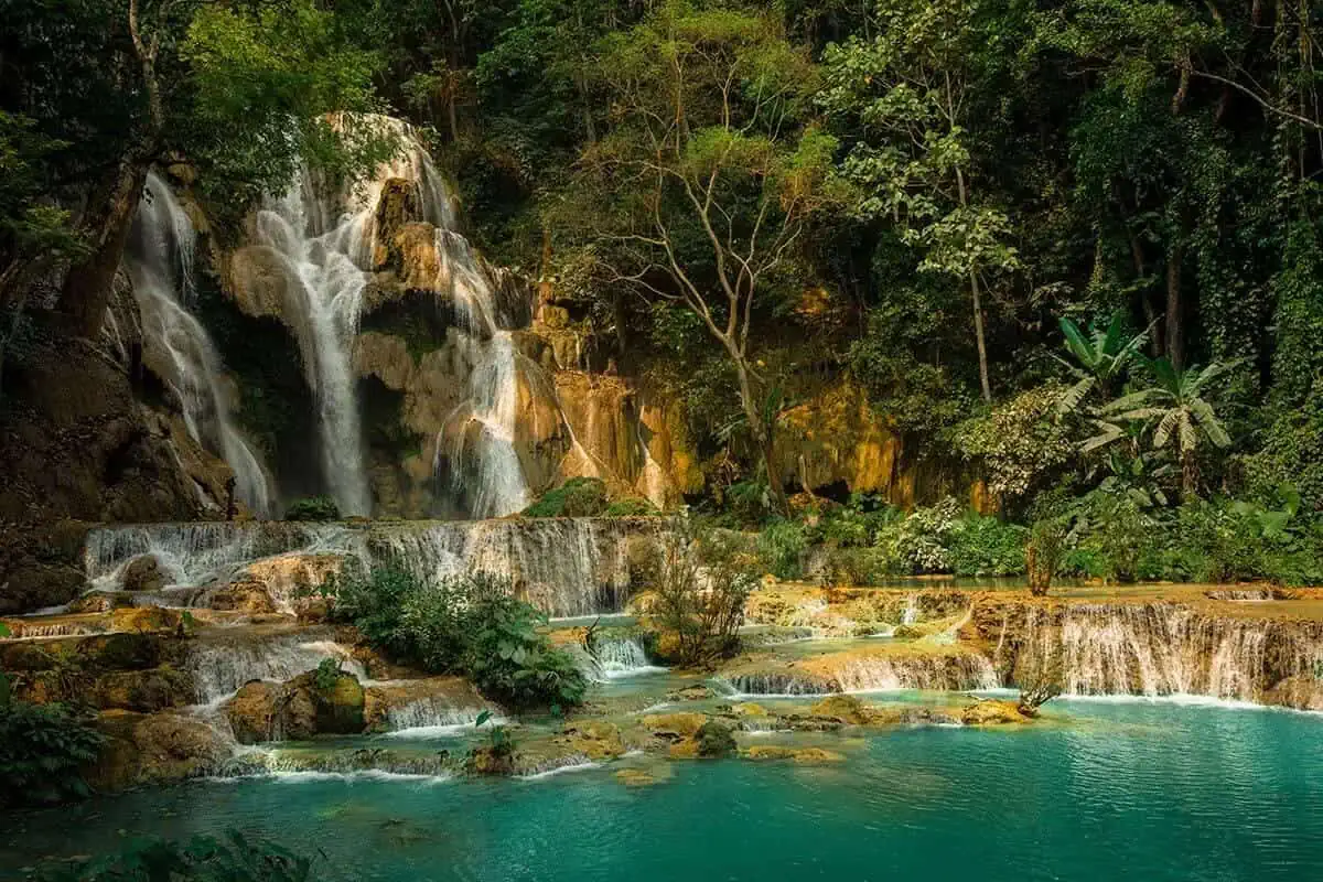 2 Weeks In Laos Itinerary: BEST Route North To South 7 the main waterfall at kuang si falls surrounded by liush jungle