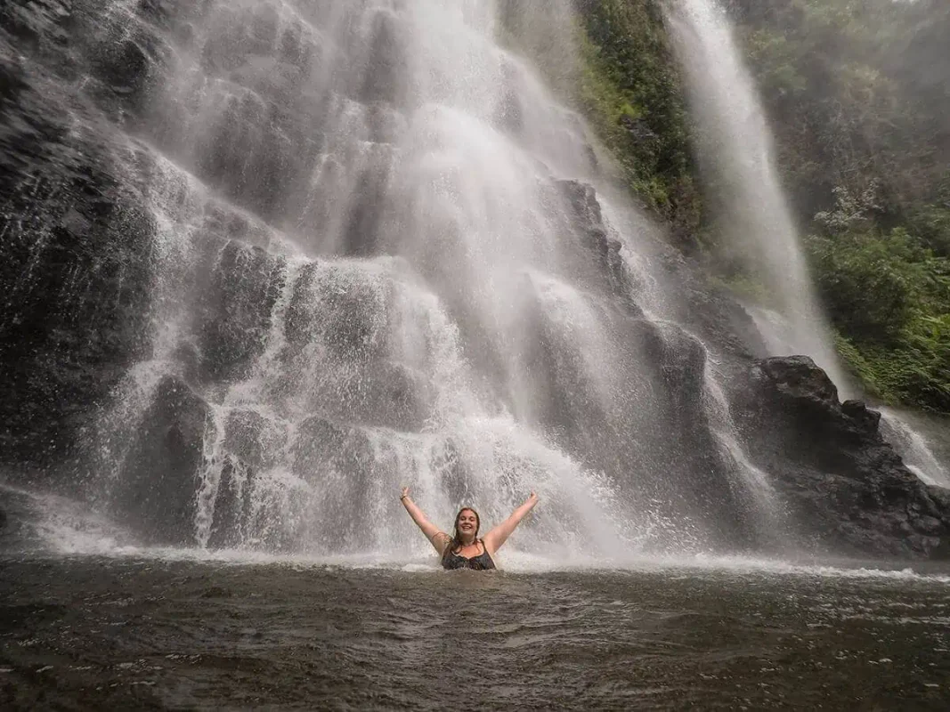 2 Weeks In Laos Itinerary: BEST Route North To South 59 tasha amy swimming underneath a waterfall outside of pakse