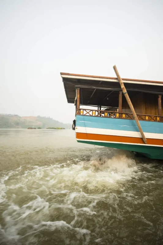 2 Weeks In Laos Itinerary: BEST Route North To South 58 the back of a slow boat with its motor whirling in huay xai