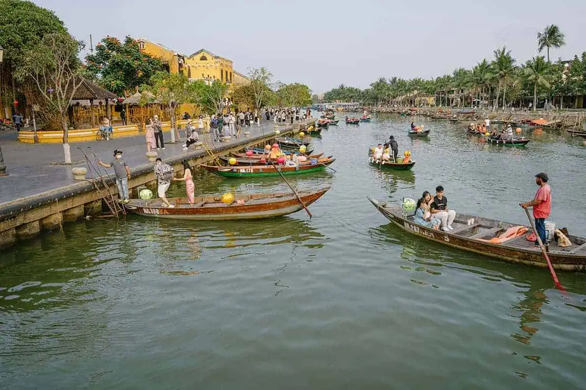 3 Week Vietnam Itinerary: BEST North To South Route 35 Bustling river scene with traditional boats and tourists in Hoi An, a vibrant part of any 3 week Vietnam itinerary.