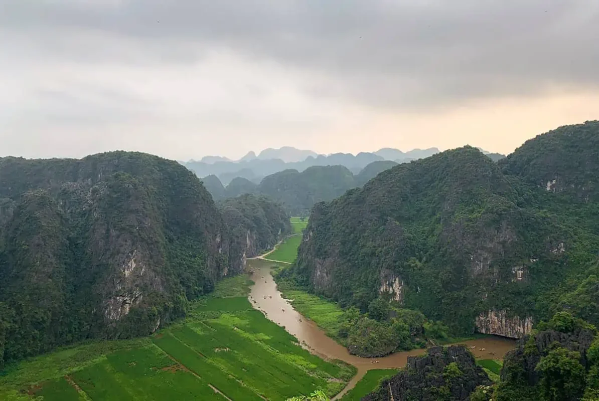 3 Week Vietnam Itinerary: BEST North To South Route 22 Majestic view of a river winding through karst limestone mountains in Ninh Binh, a natural wonder for those spending 3 weeks in Vietnam.