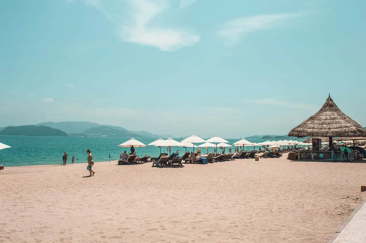 3 Week Vietnam Itinerary: BEST North To South Route 40 Serene beachfront with umbrellas and loungers under a clear sky, a slice of relaxation to be had during a 3 week Vietnam getaway.