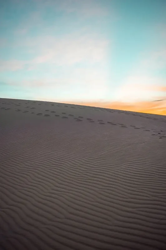 3 Week Vietnam Itinerary: BEST North To South Route 47 Sunrise casting a warm glow over smooth sand dunes, a picturesque scene to witness on a 3 week Vietnam tour.