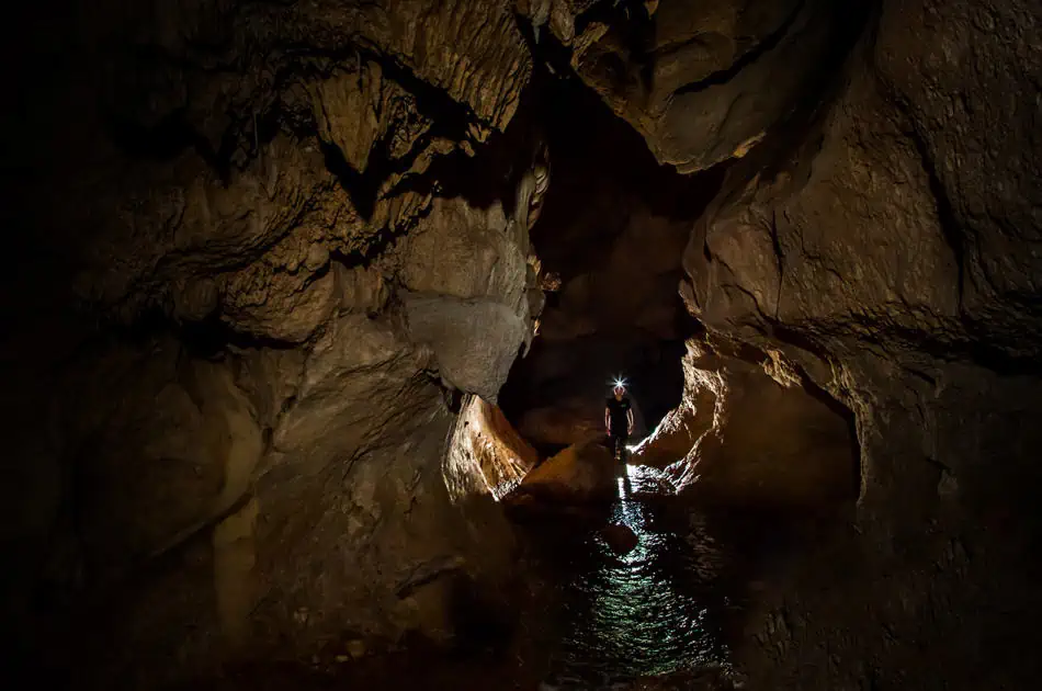 ATM Cave Tour From San Ignacio: Is It REALLY Worth The Price? 9 a lone traveler looking out into the atm cave with a head torch on
