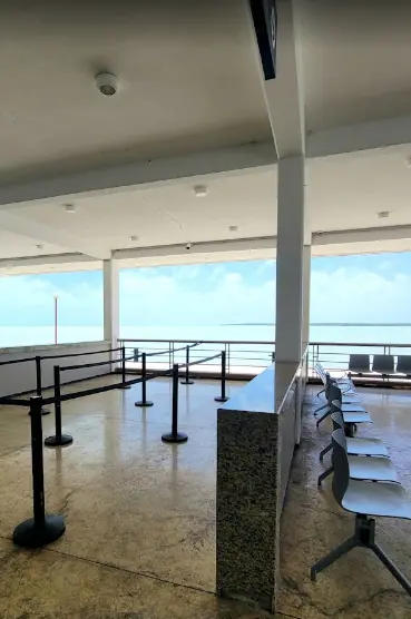 Bacalar To Caye Caulker: The ULTIMATE Travel Guide 2025 7 An empty waiting area at a ferry terminal in Chetumal, with stanchions guiding passengers and metal chairs arranged in rows.