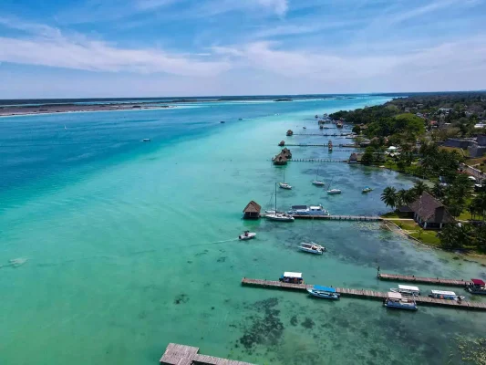 Aerial view of Bacalar's lagoon with clear waters stretching into the distance. Your starting point on the bacalar to caye caulker journey.