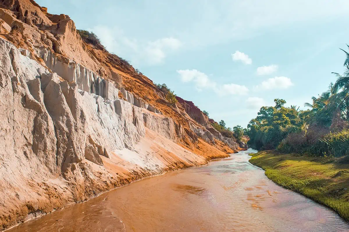 Is Mui Ne Worth Visiting & BEST Mui Ne Itinerary (2025) 4 the contrast between the orange cliffs and green jungle on the fairy stream, a must explore on your 2 days in mui ne itinerary