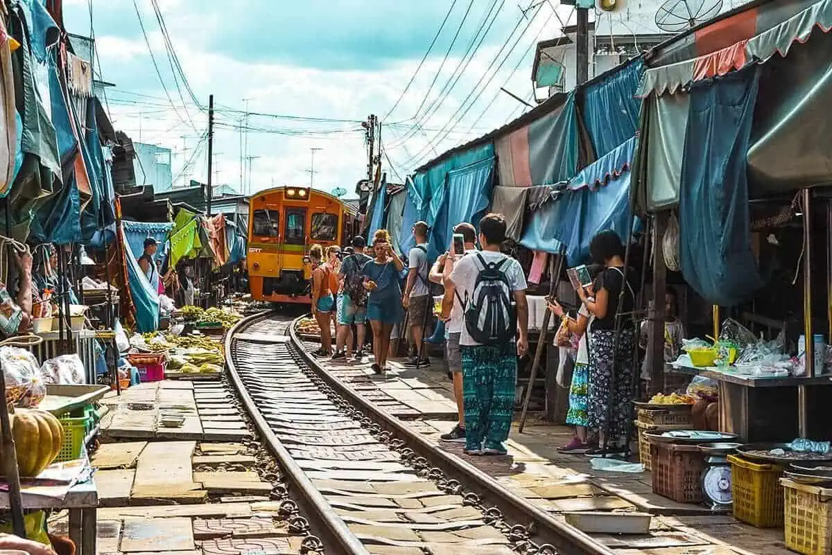 Bangkok To Chiang Mai: Bus, Train, Or Fly? 7 train driving through market on railway tracks bangkok to chiang mai