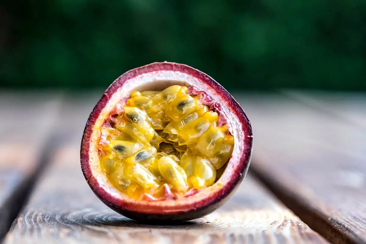 Fruits In Belize: The BEST 24 Fruits Worth Trying On Your Visit 14 Open passion fruit with a broken skin showing the juicy yellow seeds, a tart and aromatic delight among the fruits in Belize.