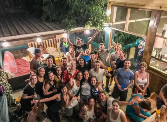 A group photo of lively backpackers enjoying a night out at Bella's Backpackers, one of the best hostels in San Ignacio, showcasing the hostel's social atmosphere.
