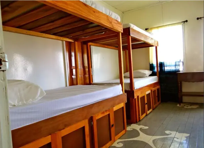 Best Hostels In San Ignacio: 5 Excellent Stays For Travelers On A Budget 4 Sturdy and inviting wooden bunk beds in a bright room at Old House Hostel, a contender for the best San Ignacio hostel.