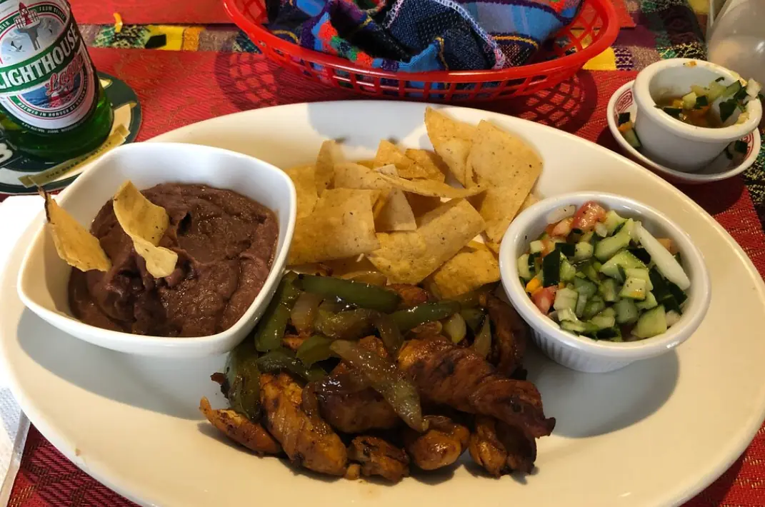 12 Best Restaurants In San Ignacio: Top Eats For Visitors 8 A hearty Belizean meal with rice and beans, stewed chicken, coleslaw, and fried plantains, served at Cenaida’s Belizean Food, one of the best restaurants in San Ignacio.