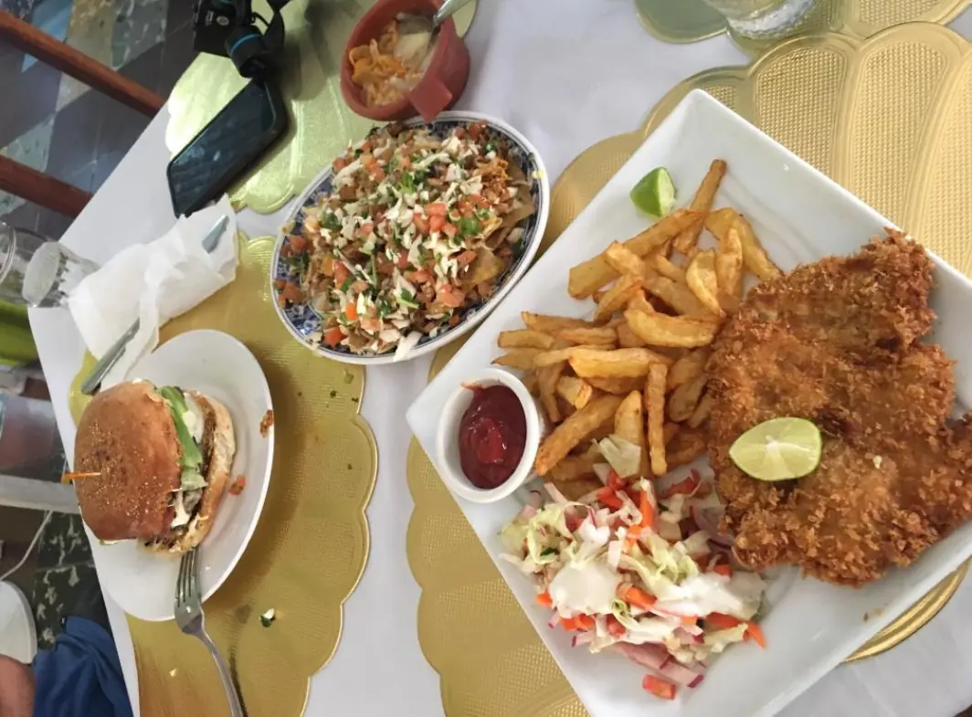 12 Best Restaurants In San Ignacio: Top Eats For Visitors 11 A casual dining spread with a burger, chicken schnitzel with fries, and a loaded seafood ceviche, exemplifying the diverse food options in San Ignacio from ervas restaurant