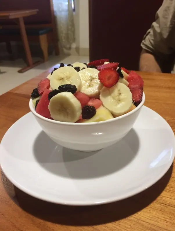 12 Best Restaurants In San Ignacio: Top Eats For Visitors 5 A healthy bowl of fresh fruit salad with banana, strawberry, and raisins, a light and nutritious option when wondering where to eat in san ignacio