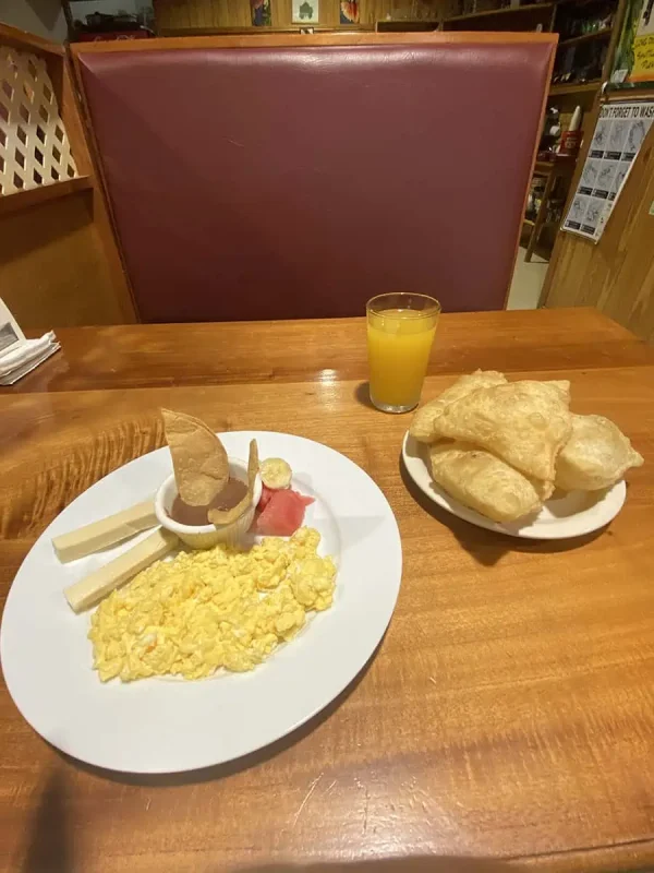 12 Best Restaurants In San Ignacio: Top Eats For Visitors 4 Simple yet satisfying breakfast consisting of scrambled eggs, cheese, ham, and fried jackfruit, served with orange juice, from pops belize restaurant. a common find in San Ignacio's cafes.