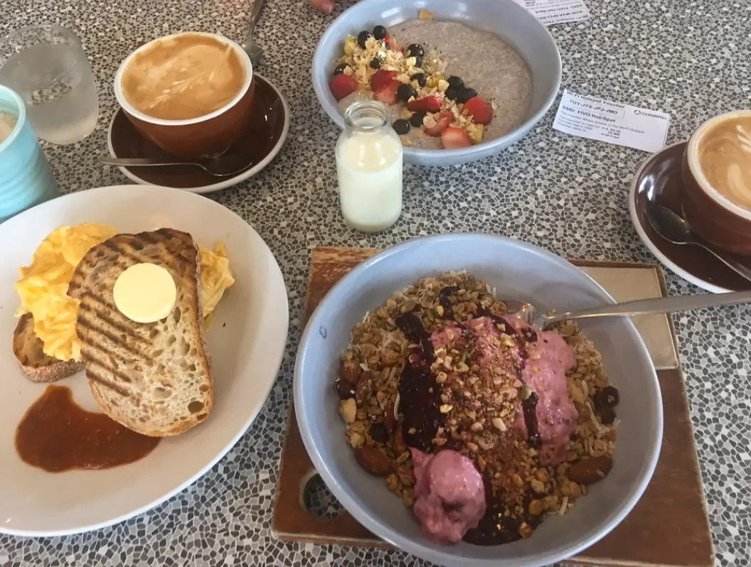 12 Best Restaurants In San Ignacio: Top Eats For Visitors 6 A hearty breakfast spread with scrambled eggs on toast, oatmeal with fruit, and a cappuccino, typical of the morning offerings at the shack cafe, one of best restaurants in San Ignacio.