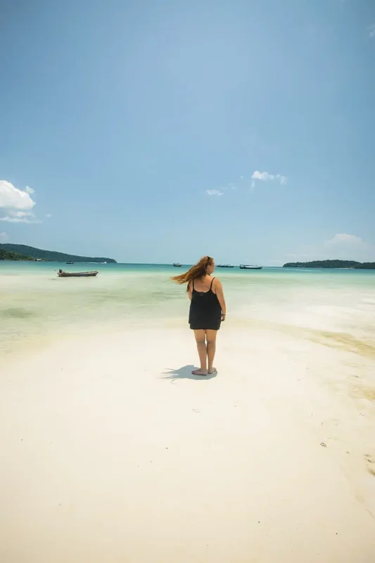 22+ Cheapest Countries To Backpack In The World! (2025) 13 A woman walking on a sandy beach in cambodia, one of the cheapest countries to travel.