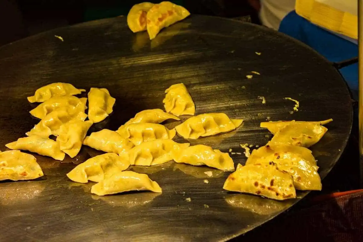 Chiang Mai Sunday Night Market: BEST Tips & Guide (2025) 11 Freshly cooked dumplings on a hot griddle ready to be served to market goers.