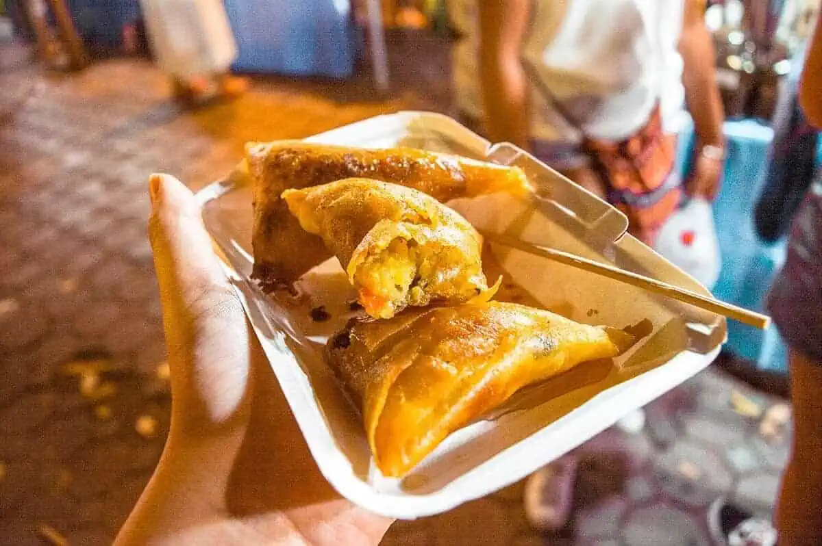 Chiang Mai Sunday Night Market: BEST Tips & Guide (2025) 6 Freshly made samosas being served to eager foodies at a food stall in the Chiang Mai Sunday Market.