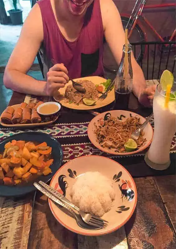 Chiang Mai To Luang Prabang: All You Need To Know 2025 10 a table of spring rolls, fried rice, pad thai, and sweet and sour tofu, as well as drinks from a restaurant in chiang khong