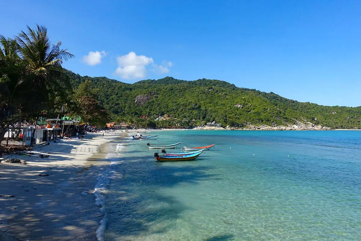 boats lined up on the shore of haad rin in koh phangan