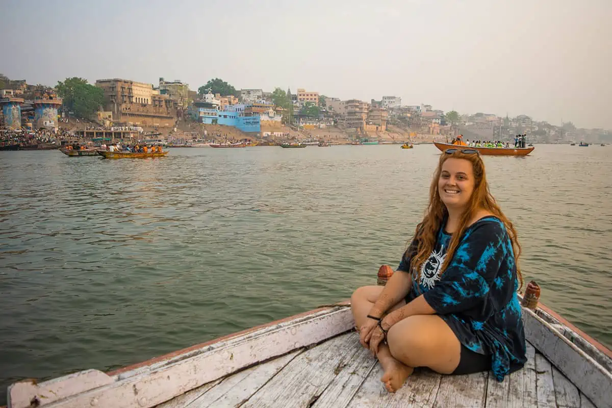 22+ Cheapest Countries To Backpack In The World! (2025) 21 A woman sitting on a boat on the ganges river in varanasi.