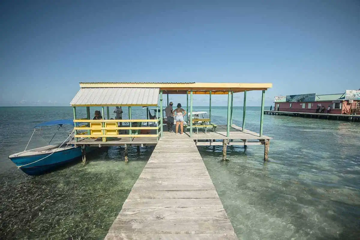 Is Caye Caulker Safe? BEST Tips For Travelers 2025 15 Locals and tourists mingle on a sunny Caye Caulker pier, indicating a safe and sociable environment for leisure activities.