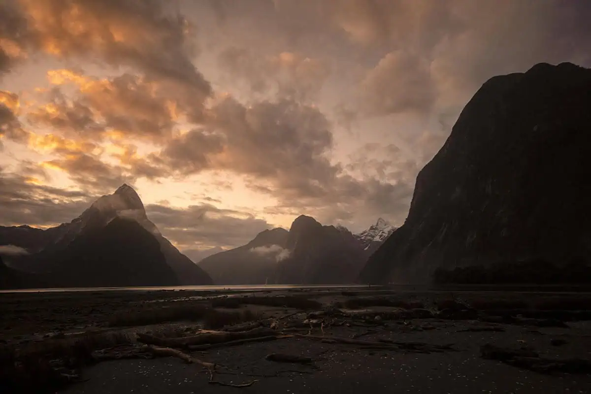Is Milford Sound Worth It? My Pros & Cons 1 Sunset over Mitre Peak at Milford Sound, New Zealand, with clouds glowing orange and pink, answers the question is milford sound worth it