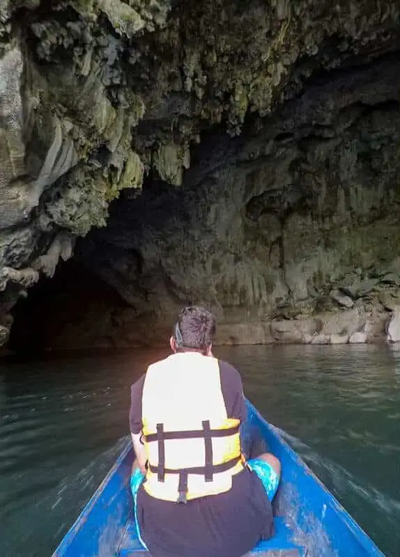 Kong Lor Cave, Laos: ULTIMATE Guide (2025) 16 a man on a longtail boat going back through kong lor cave
