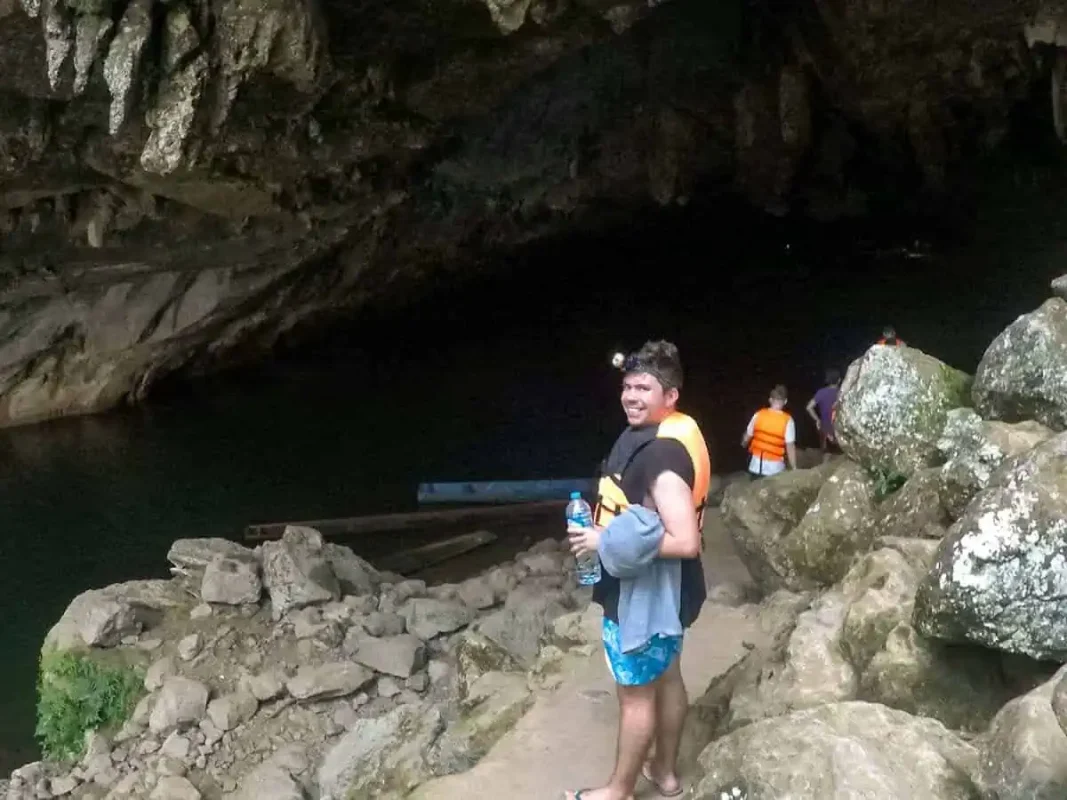 Kong Lor Cave, Laos: ULTIMATE Guide (2025) 18 a man waiting to go on the boat inside tham kong lo